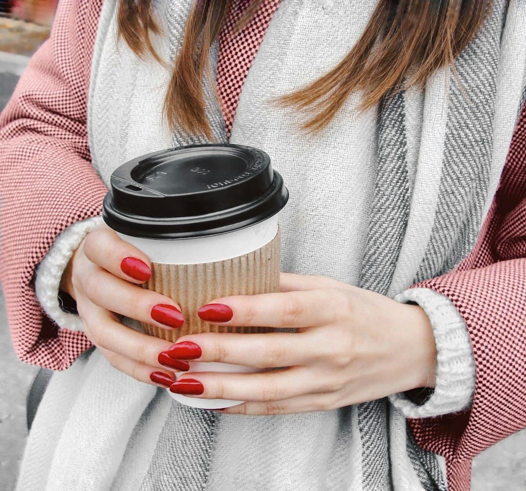 Deep oxblood-red manicure on classic-length nails, high gloss.